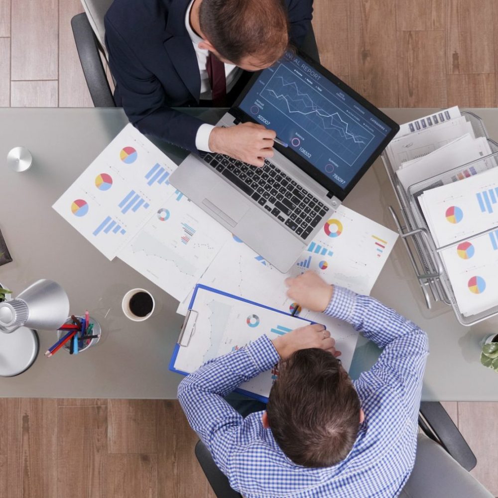 Top view of businessmen analyzing management statistics while working at company investments